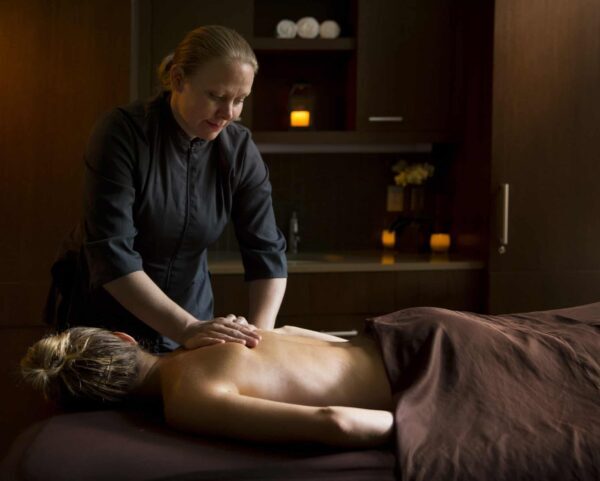 Licensed Massage Therapist performs a message on a female guest.