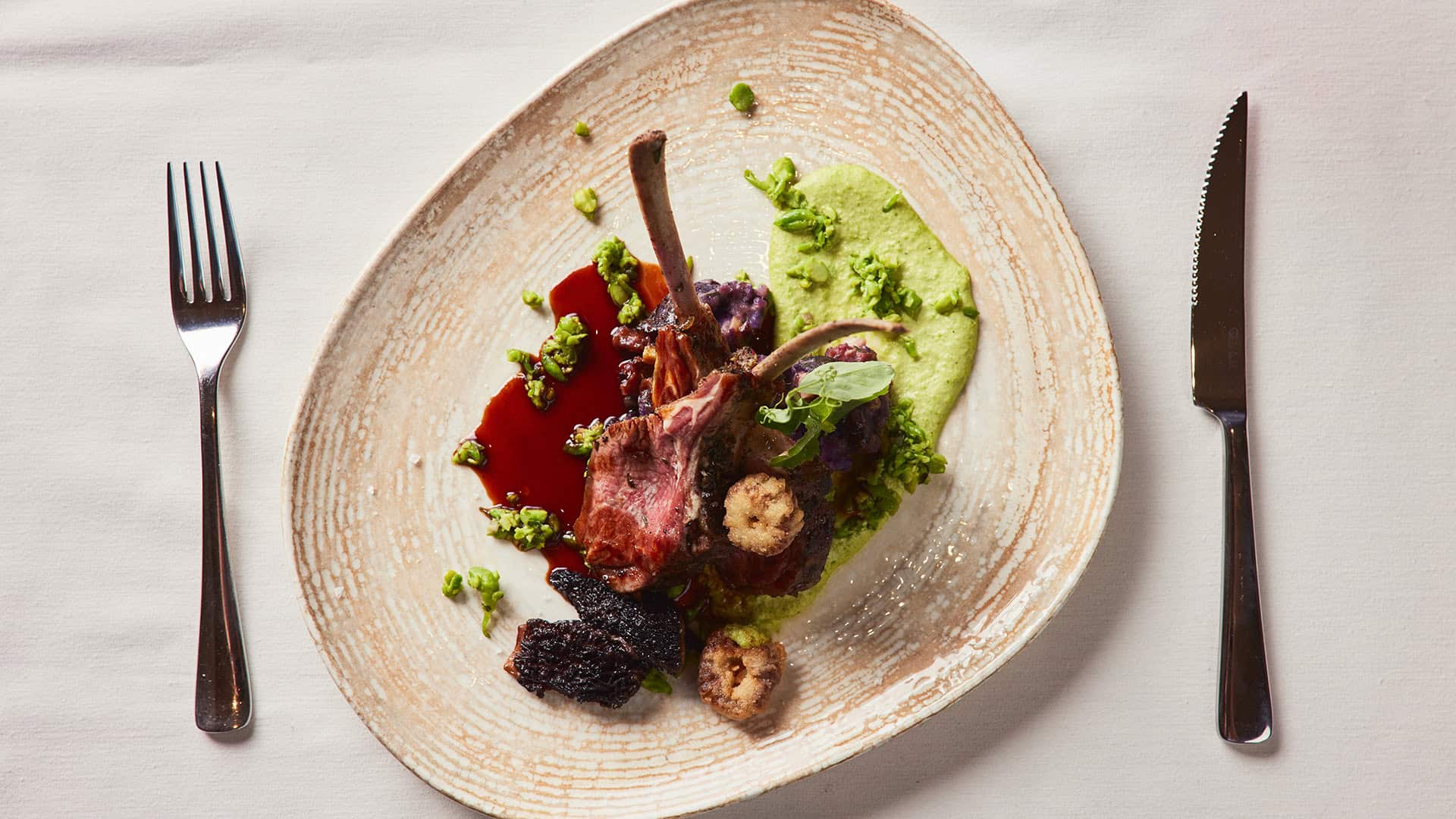 Rack of Lamb with Pea Pistou, Purple Potato, Fried Morels, Lamb Bacon