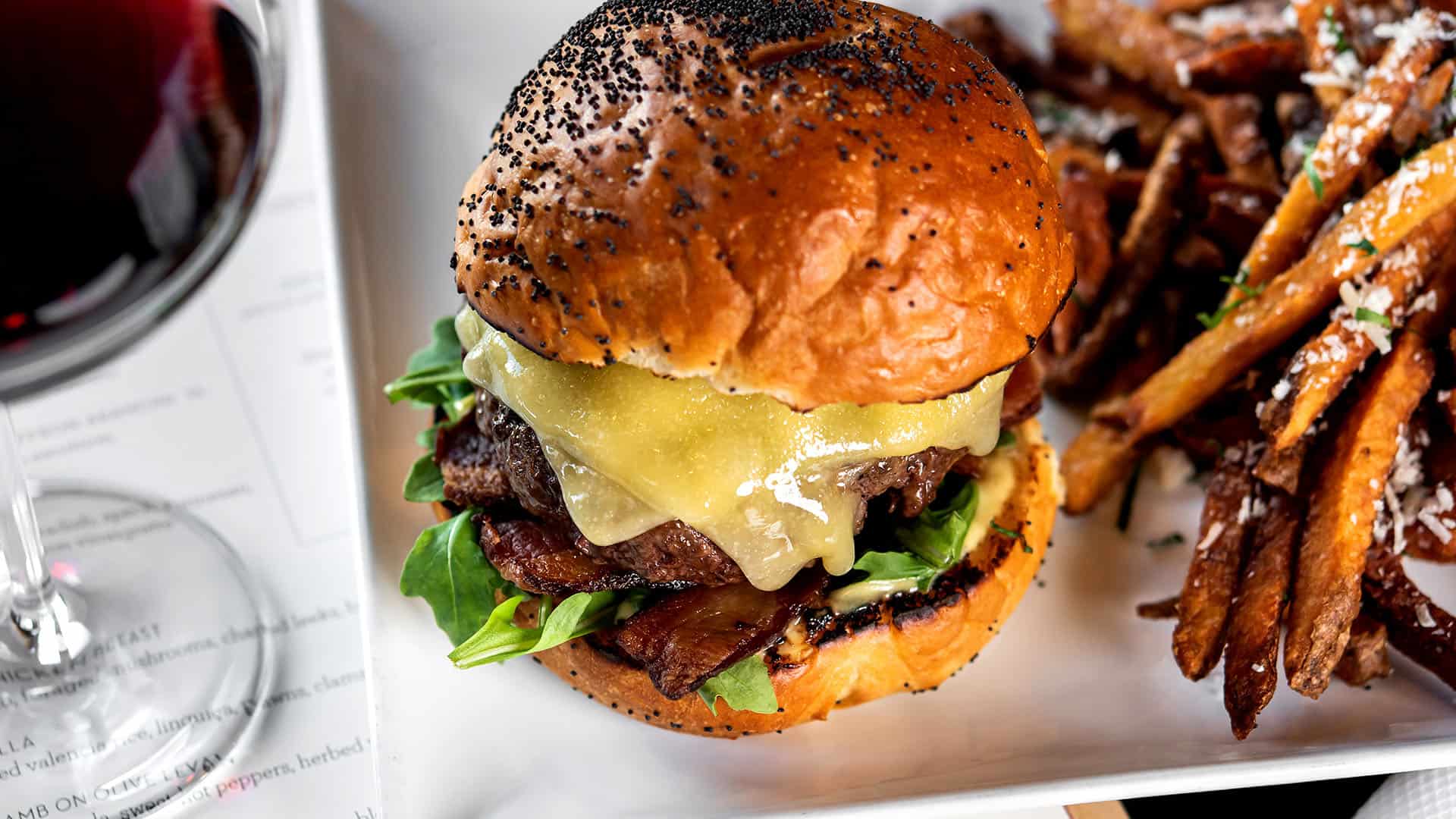 Pinot Burger - tillamook white cheddar, arugula, dijon aioli, charred onion relish, jory bacon, house brioche bun, served with fries.