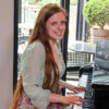 Sophia Kay Johnson seated at the piano in The Allison's living room.