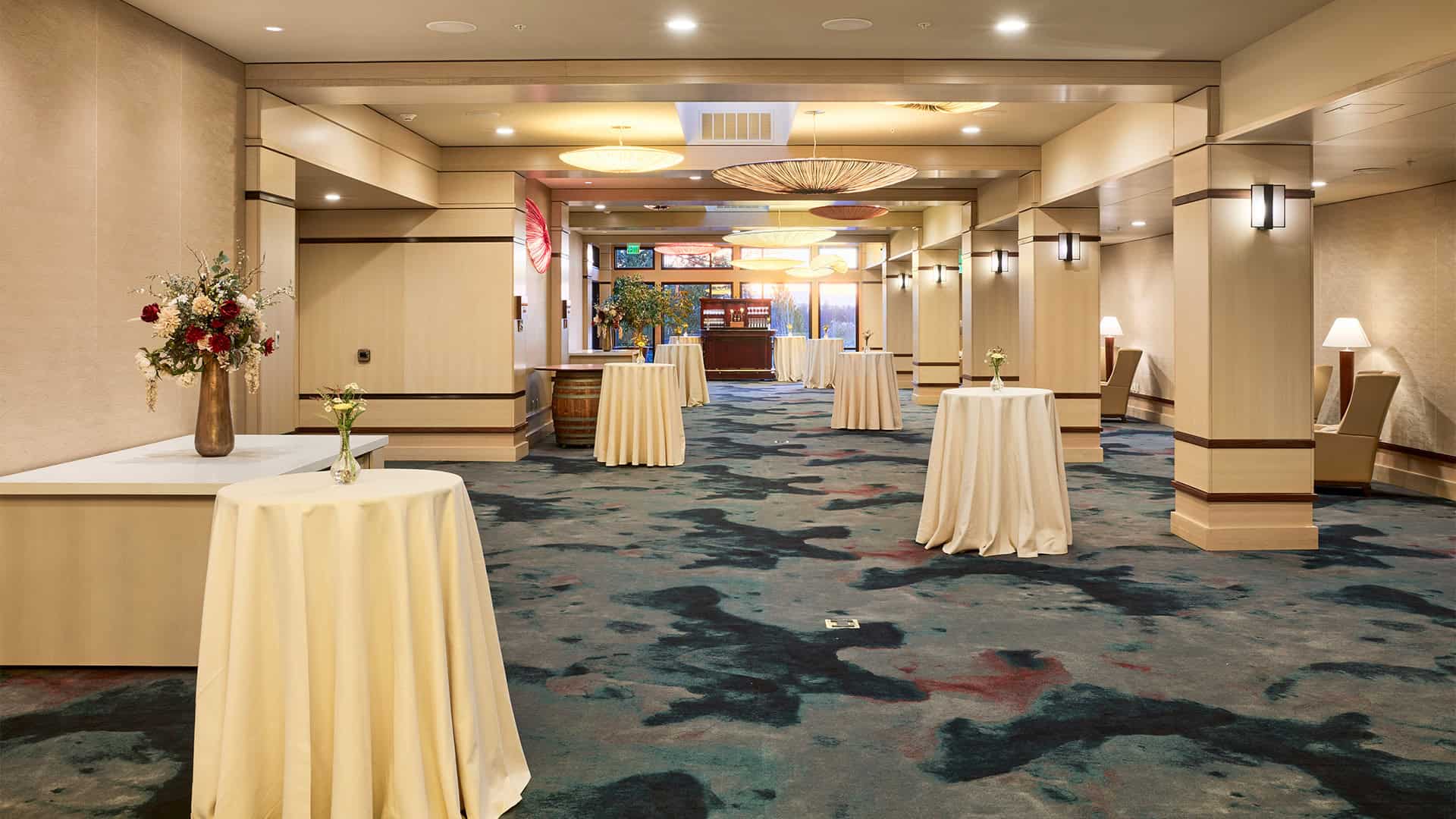 Grand Reception Foyer set for a reception style event with bistro tables, banquet table for serving and bar.