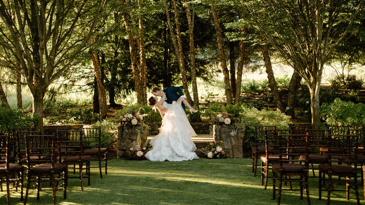 Newlyweds on the steps of the Meadow Garden kissing for the first time after their ceremony.