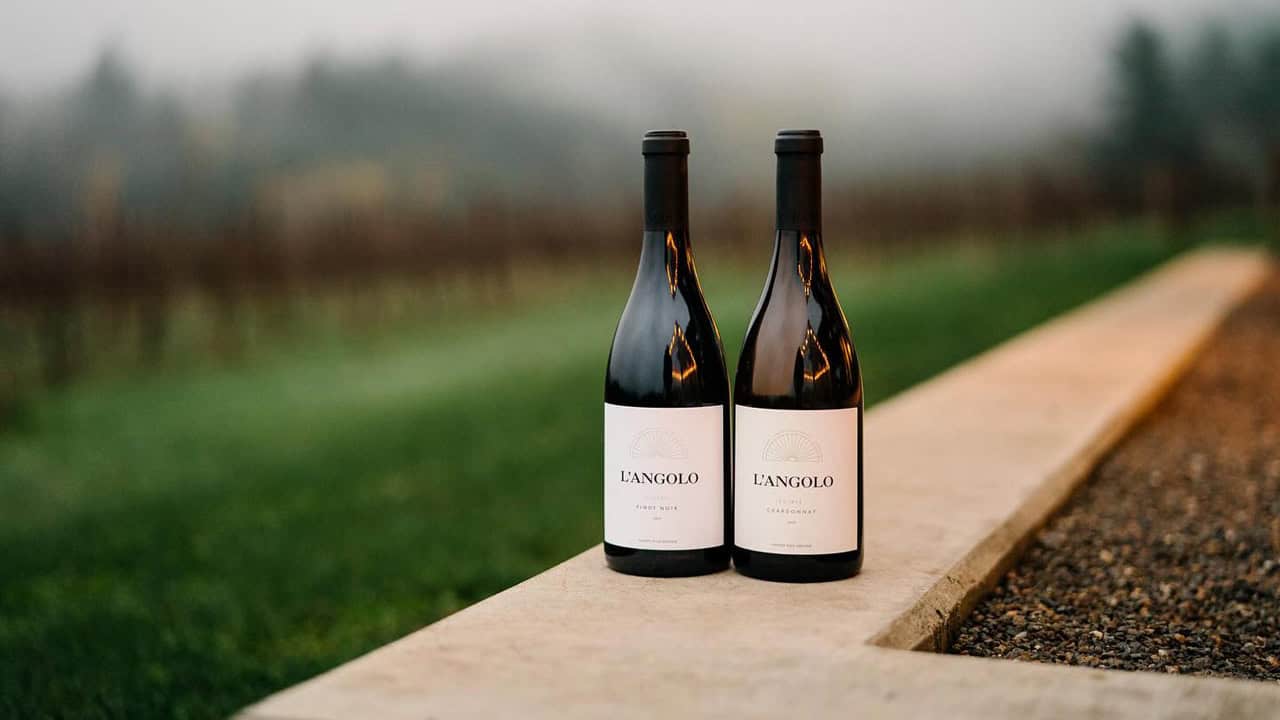 Two bottles of L'Angalo wines on an outdoor patio.