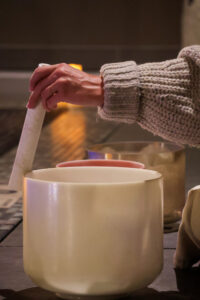 A meditation instructor creating sounds on a bowl during a float meditation session.