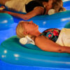Four guests resting on flotation devices in the vanishing-edge pool at The Allison.