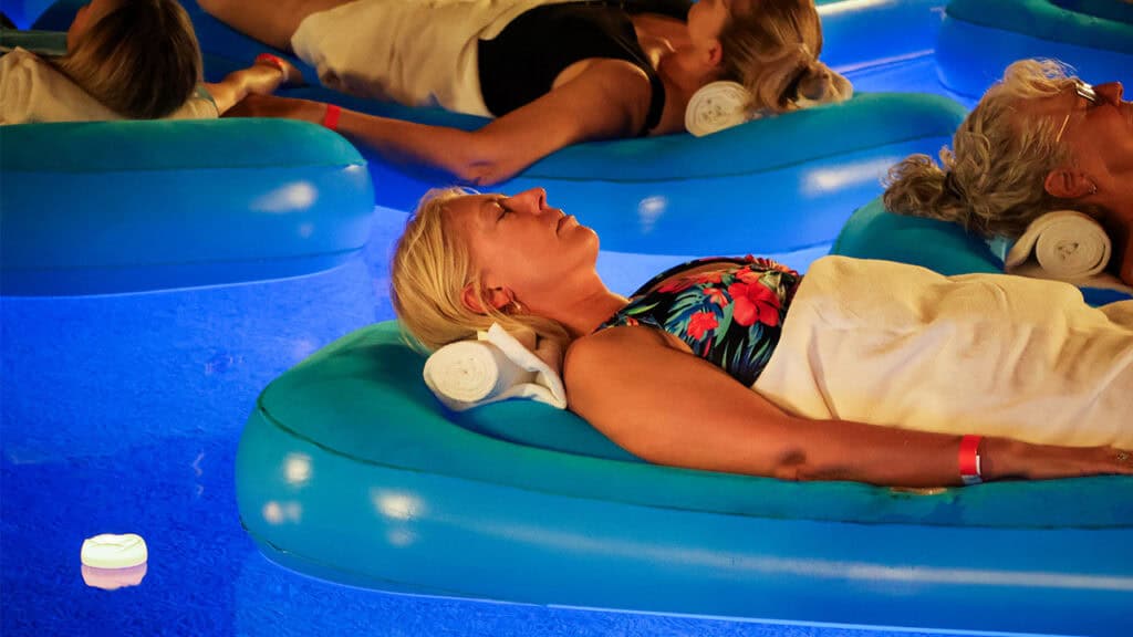 Four guests resting on flotation devices in the vanishing-edge pool at The Allison.