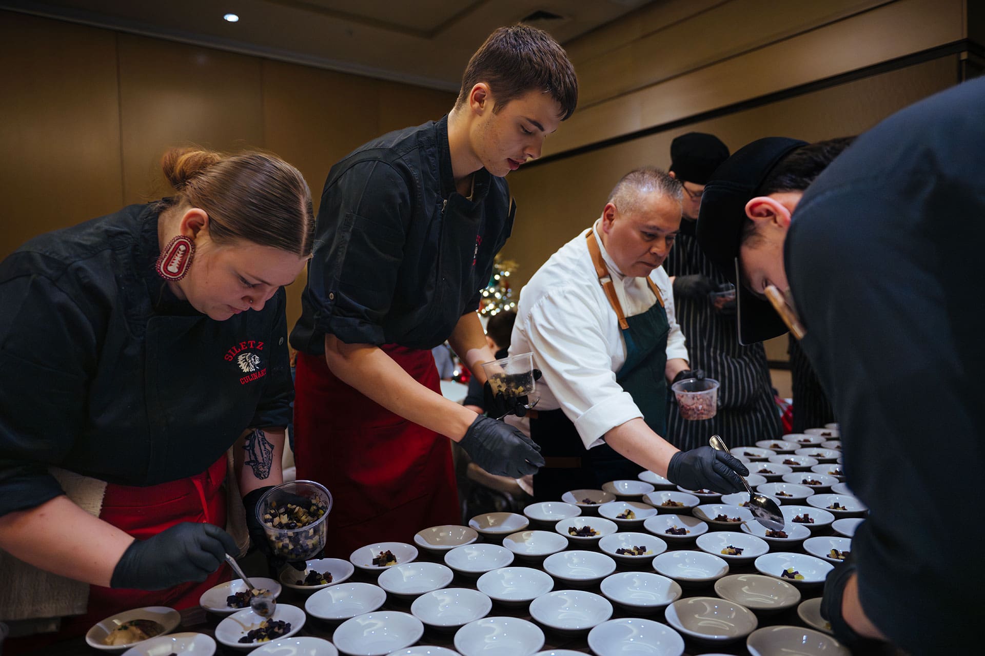 Chef Jack plating the first course dishes with three Siletz culinary students.