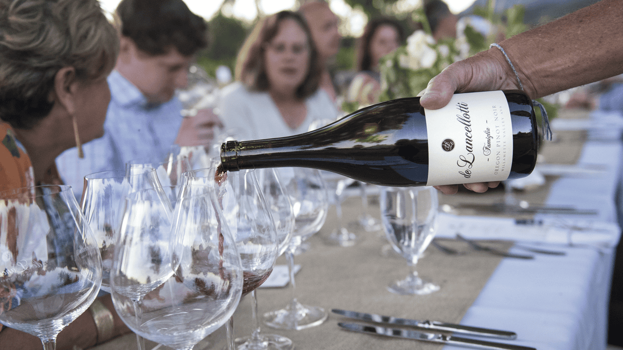A bottle of de Lancellotti wine being poured at a dinner.