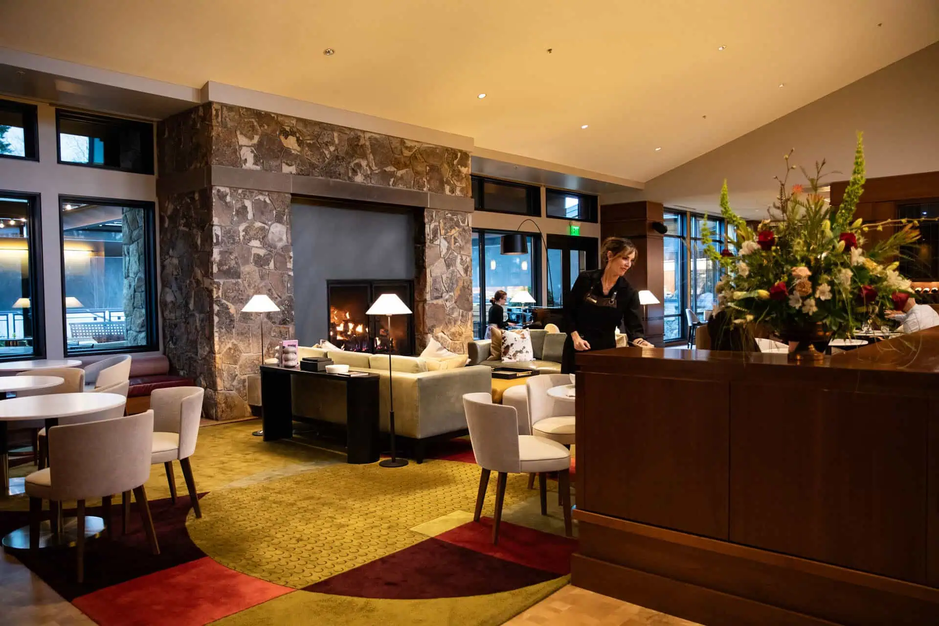 The Allison living room area with cozy fireplace, soft seating and grand piano.