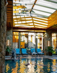A female guest floating weightlessly in the pool under the skylight.