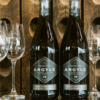 Two bottles of wine from Argyle Winery surrounded by wine glasses.