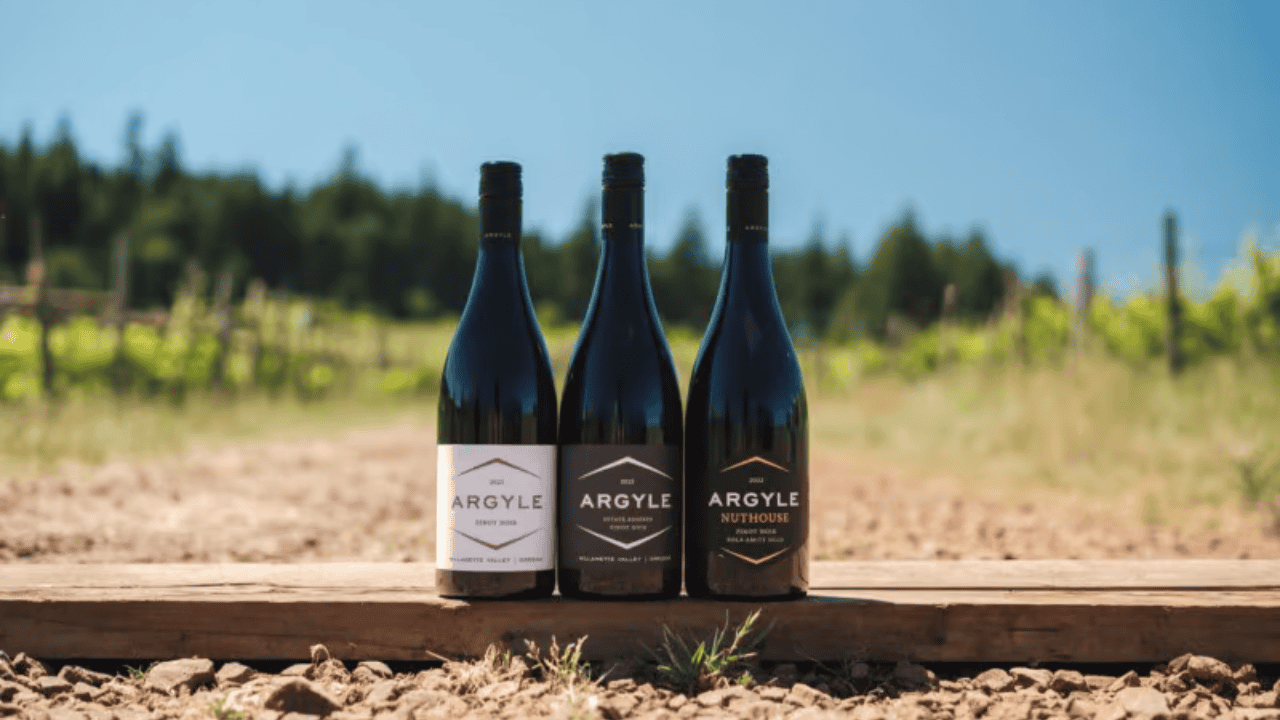 Three bottles of wine from Argyle Winery in the vineyard.