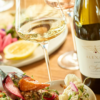 A bottle of wine from Alexana Winery with a glass and food.