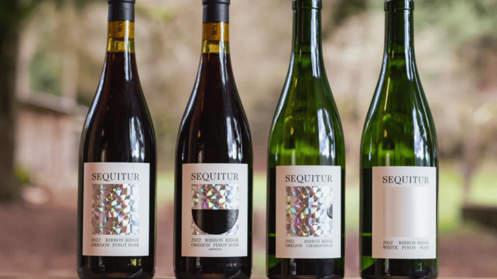 Four bottles of Sequitur Wine near the forest.