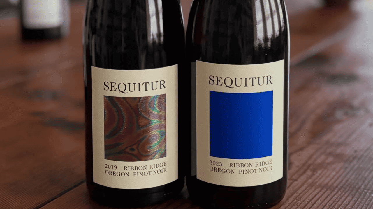 Two bottles of Sequitur Wine on a wood table.