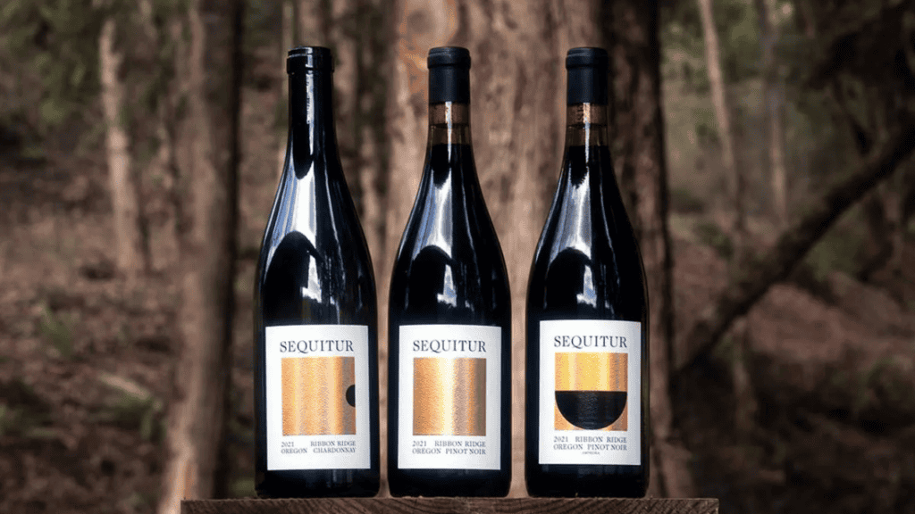 Three bottles of Sequitur Wine set amongst the trees.