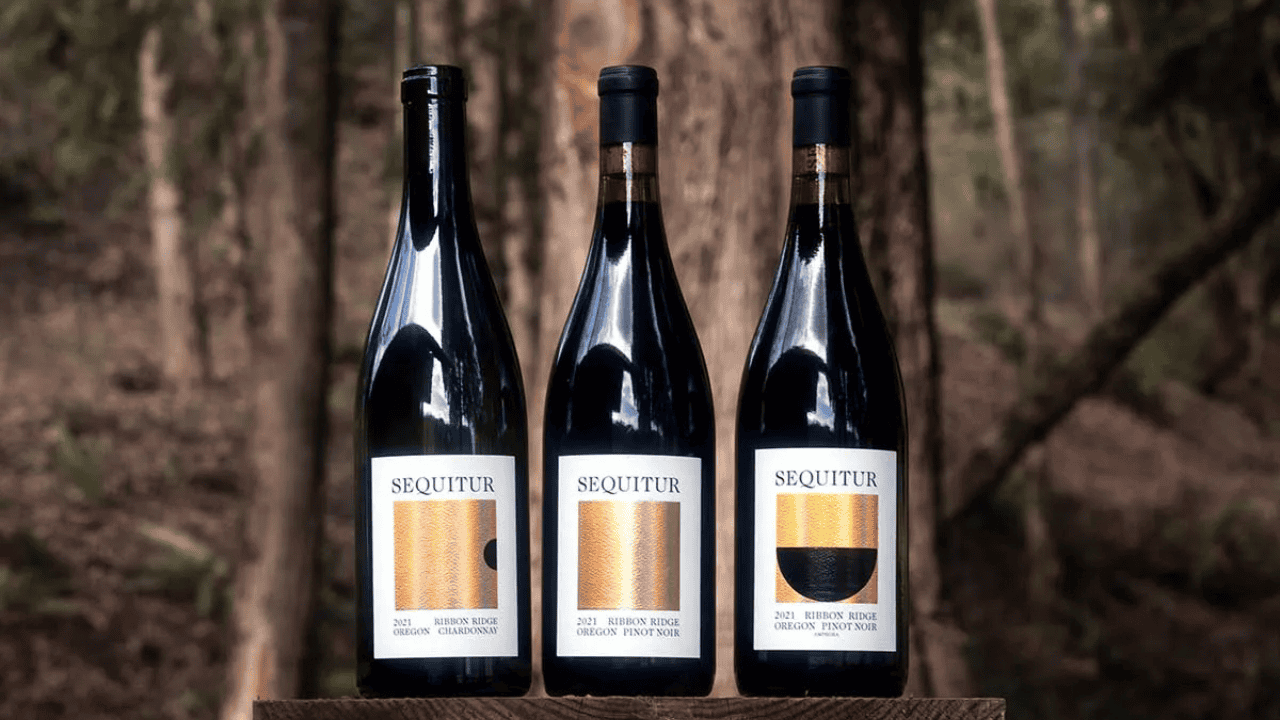Three bottles of Sequitur Wine set amongst the trees.