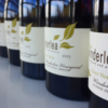 An up-close shot of the labels on Winderlea wine bottles.