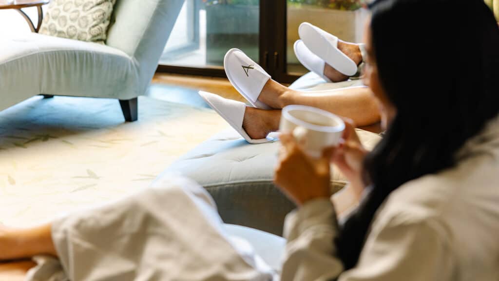 Three female guests in robes, lounging in the spa drinking tea.