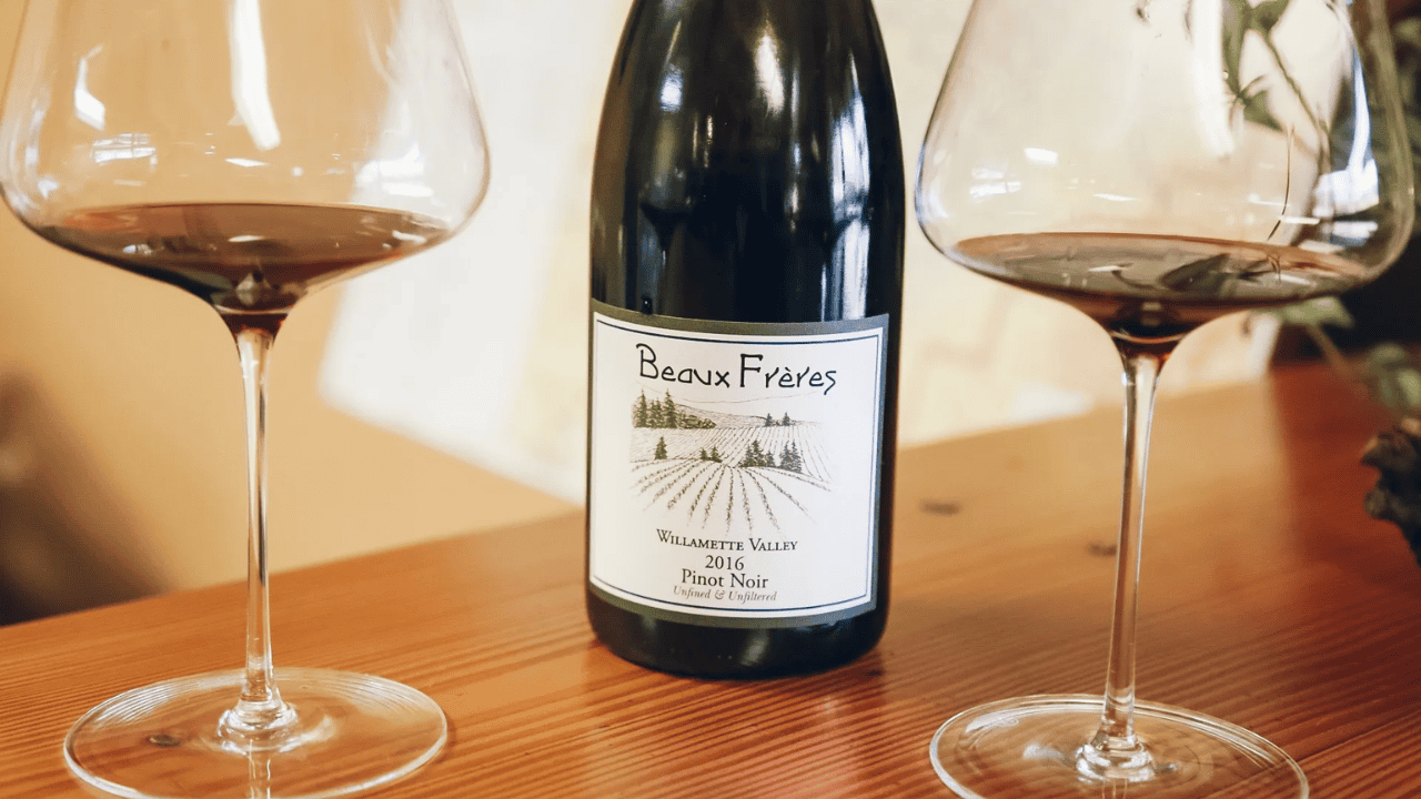 A bottle of wine and two wine glasses from Beaux Frères.