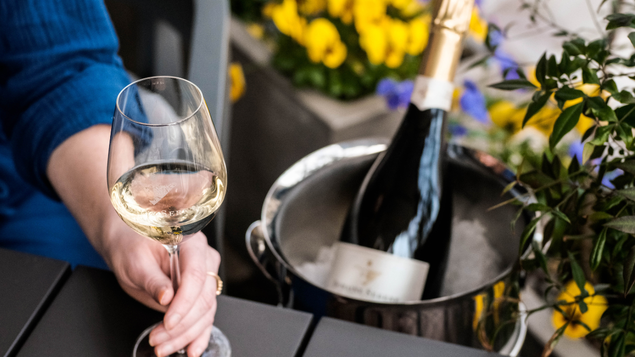 A bottle of Domaine Serene's wine with a person holding a glass.